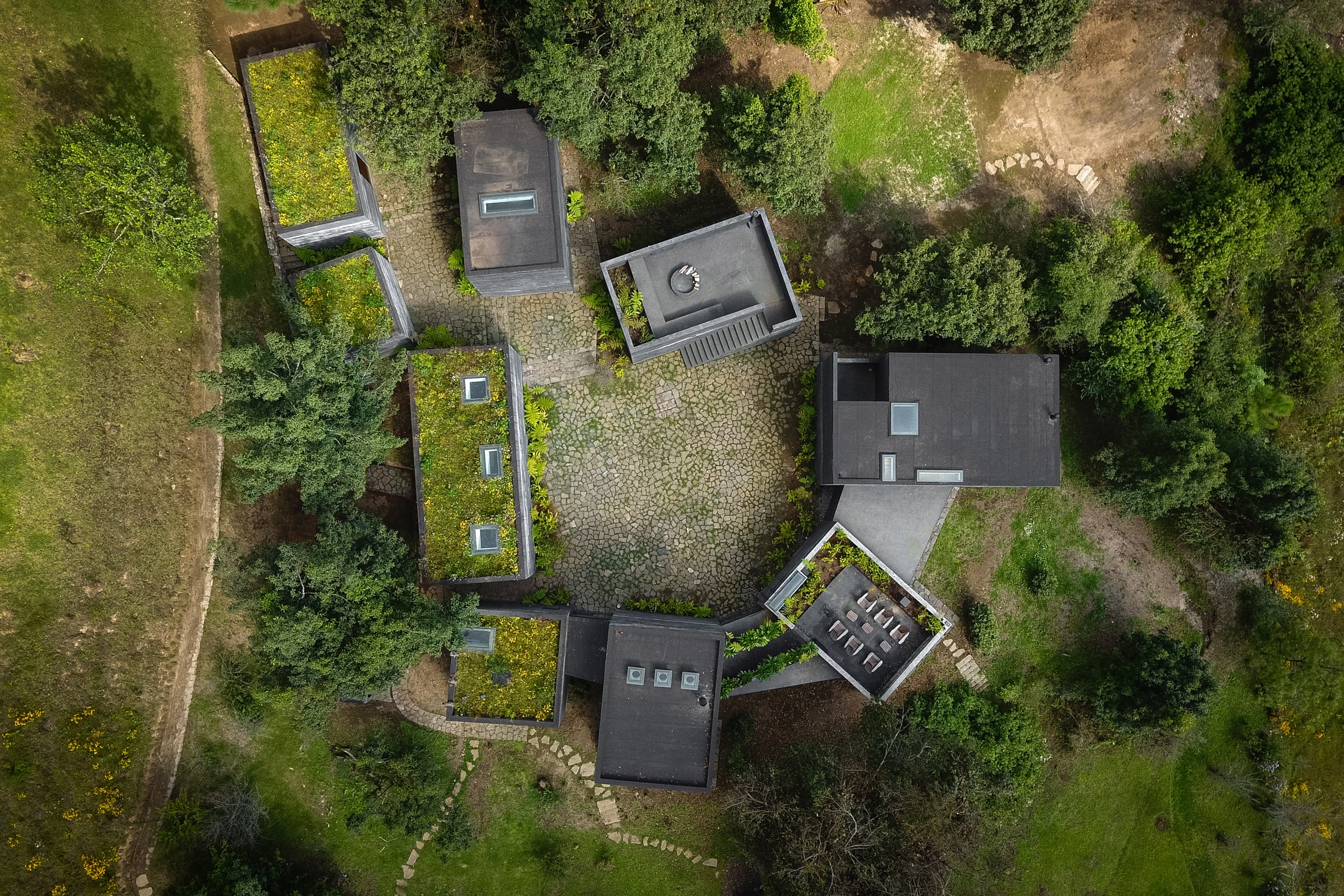 CAJAS DE CONCRETO NEGRO FORMAN CASA BRUMA EN MÉXICO RURAL